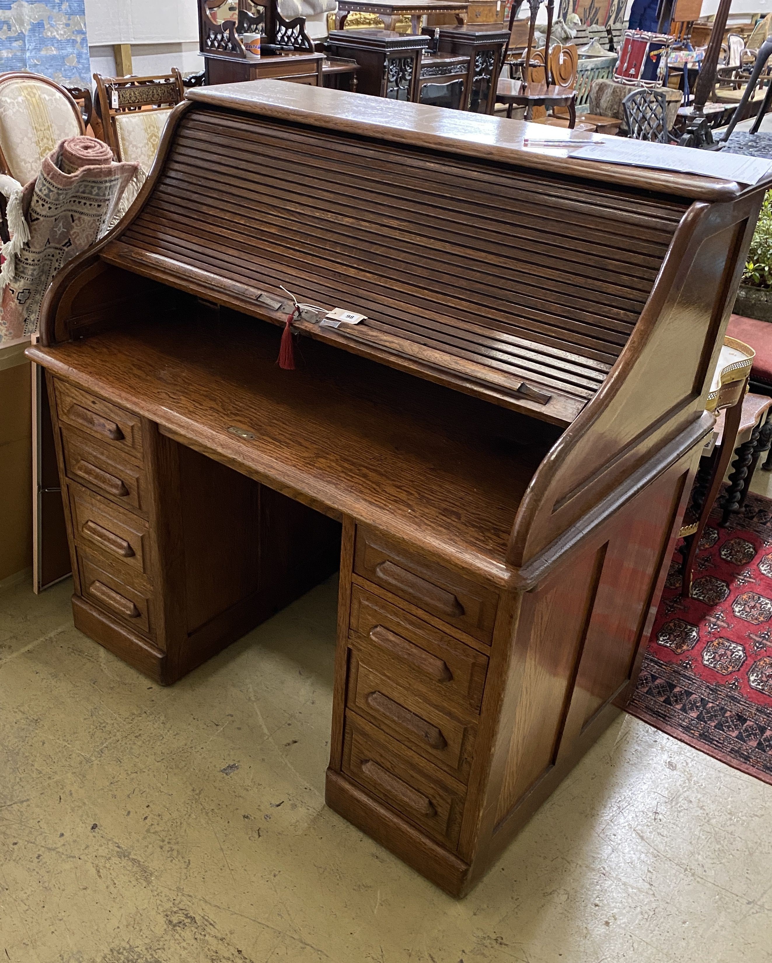 An early 20th century oak roll top desk with 'S' shaped tambour, width 122cm, depth 78cm, height 124cm